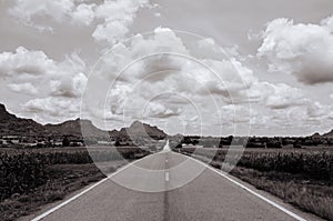 Wide long endless road in grass plain and mointain valley. Black and white