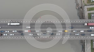 Wide multi-lane bridge with driving trucks and traffic jam
