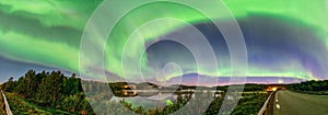 Wide Panorama Aurora borealis, Northern green lights with lot stars in the night sky over mountain lake, mirrored reflection in