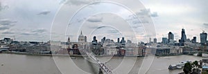 Wide panorama of the city of london along the thames showing the financial district skyscrapers and historic buildings