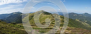 Wide panorama of grassy green hills and slopes at ridge of Low Tatras mountains with hiking trail footpath, mountain