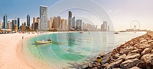 Wide panorama of Persian Gulf with sandy beach and Bluewaters Island with the worlds famous largest Ferris wheel Dubai Eye and