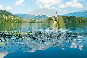 Wide panoramic view of the beautiful Bled lake, Slovenia, Europe, summer day, the clouds are reflected in the water, in the