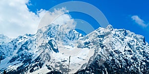 Wide panoramic view of snow covered mountain peak and blue sky with clouds in Baisaran Valley Mini Switzerland, Pahalgam,