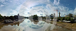 Wide panoramic view of the thames at kew brige with houseboats and surrounding buildings