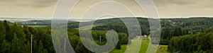 wide panoramic view from the top of a high hill to the mountainous wooded area of the ski resort in the summer photo