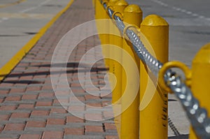 Chain along a yellow post line on a street photo