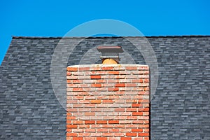 Wide red brick chimney with cap