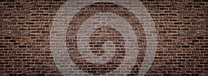 Wide red shabby brick wall texture. Masonry panorama. Dark rough brickwork panoramic background