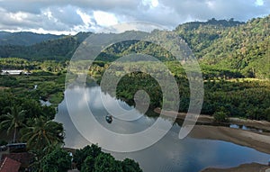 A wide river surrounded by tropical forests is in East Java, Indonesia