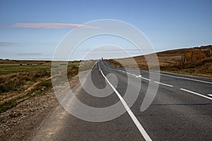 Wide road with markings in the middle of the field