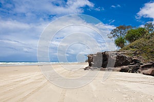 Wide sandy beach on Fraser Island, East Australia. Tire tracks of cars in the sand 
