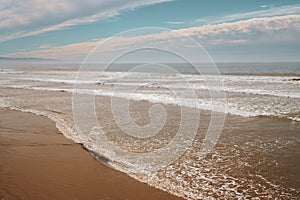 Wide sandy beach and ocean view at sunsetwith beautiful cloudy sky on bakground, Pismo Beach, California