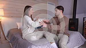 Wide shot angry young beautiful woman shouting hitting man sitting on bed crying. Disappointed Caucasian girlfriend