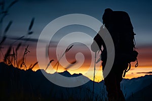 wide shot of backpacker silhouette against the alpine glow