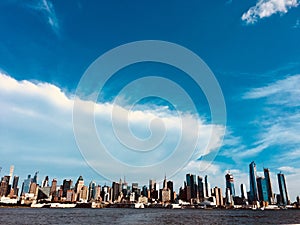 Wide shot of the beautiful sea and the high-rise building on the shore under the cloudy sky