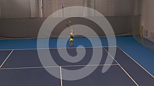 Wide shot of beautiful young sportswoman serving ball in big tennis game. Confident concentrated Caucasian woman playing