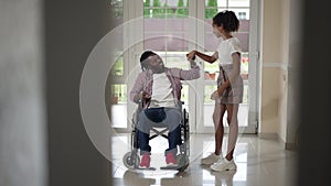 Wide shot cheerful teenage girl dancing in slow motion with disabled man in wheelchair. Portrait of happy carefree