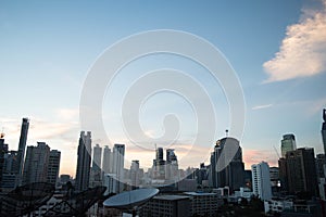 Wide shot of the cityscape with tall skyscrapers and three satellite dishes visible