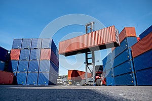 Wide shot of crane truck level up cargo container tank also show stack or layer of containers with different color, blue and brown