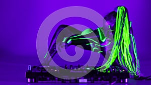 Wide shot cyborg woman dancing on DJ set in ultraviolet light looking at camera. Flexible slim Caucasian performer with