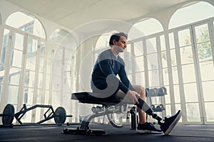 Wide shot of disabled male athlete putting on his prosthetic leg - training for the Paralympics photo
