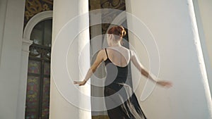 Wide shot of elegant slim ballerina walking on tiptoes up urban stairs. Camera follows graceful young Caucasian woman in