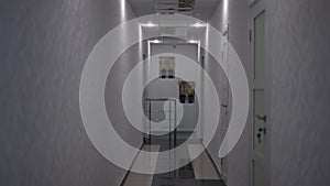 Wide shot front view hallway in hospital with no people. Interiors of modern medical clinic corridor with no one indoors