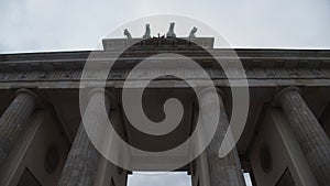 Wide Shot of going troiugh Brandenburg Gate, Brandenburger Tor in Berlin, Germany with Overcast Sky