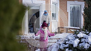 Wide shot grandmother and granddaughter on winter porch as girl running away in slow motion leaving. Happy senior