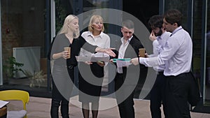 Wide shot group intelligent business people discussing startup project standing on office terrace on sunny day