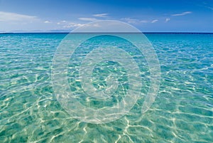 Wide shot of isolated paradise beach with calm clear waters