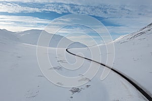 Wide Shot of Jeep Car driving on Iceland Road with Snow white Mountains and Sunset countryside, Winter. Road trip in Nordic