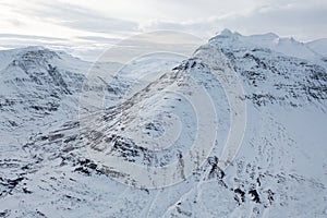 Wide Shot of Jeep Car driving on Iceland Road with Snow white Mountains and Sunset countryside, Winter. Road trip in Nordic