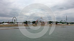 Wide Shot of large Fun Fair `Rheinkirmes` with Ferris Wheel, Roller Coaster, Carnival Rides filmed from the River Rhine. It`s one