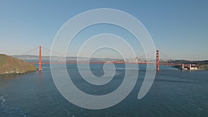 Wide shot of large suspension bridge over water in bay. Forwards fly towards Golden Gate Bridge. San Francisco