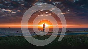 Wide shot of a lighthouse on the beach with the sunset in Domburg / Westkapelle Netherlands