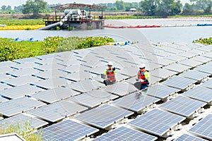 Wide shot of one professional technician worker point to the right and discuss with co-worker to work with solar cell panel system