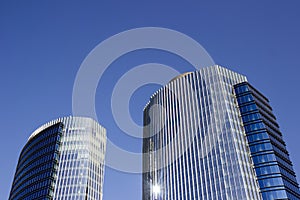 Wide shot of a pair of twins corporate blue office high-rise buildings with a striped design.