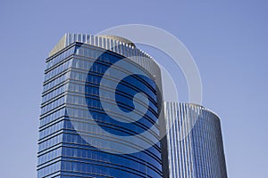 Wide shot of a pair of twins corporate blue office high-rise buildings with a striped design.