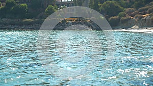 Wide shot of picturesque landscape with Mediterranean sea waves rolling on coast in slow motion reflecting sunshine