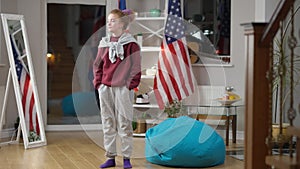 Wide shot portrait of angry frustrated woman standing in living room kicking bag chair thinking. Troubled Caucasian