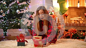 Wide shot portrait of cheerful excited teenage girl opening Christmas gift box with light inside smiling. Happy