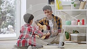 Wide shot portrait of smiling positive Middle Eastern teenager playing song for brother distracting musician, and
