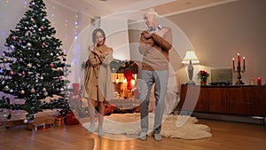 Wide shot positive Caucasian granddaughter and grandfather dancing simultaneously gesturing high-five clapping laughing