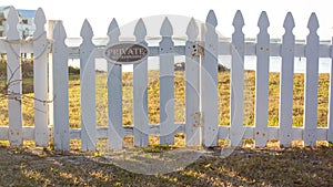 Wide shot - Private No Trespassing sign on picket fence