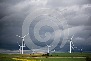 Wide Shot Of Renewable Wind Power Farm Windmills In Motion With A Cloudy Epic Sky In Valdorros In Castile and Leon, Burgos, Spain