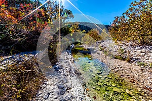 Wide Shot of a Rocky Stream Surrounded by Fall Foliage with Blue Skies at Lost Maples