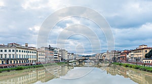 Wide shot of the Saint Trinity bridge over the river near apartment buildings under the cloudy sky