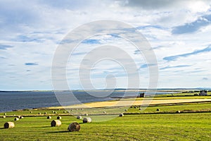 Wide shot of a seashore with hay bales in the far north of Scotland near Wick, Caithness
